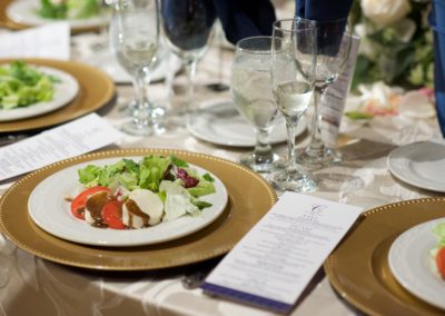gold plates on ivory linens with navy wedding menus