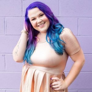 Jessica's headshot of her rad self smiling with purple and blue hair
