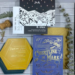 Image of foil printed invitations on white brick background