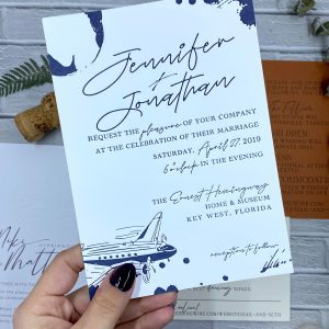 woman holding letterpress stationery samples against background of white brick
